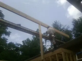 Carpenter setting a ridge beam over a new addition frame — Ice Dam Removal by Roofing Brothers in Triadelphia