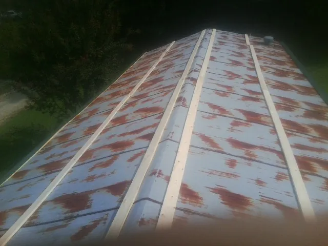 Rusted metal roof panels with new wood purlins before replacement — Storm Damage Roof Repair in Triadelphia by Roofing Brothers