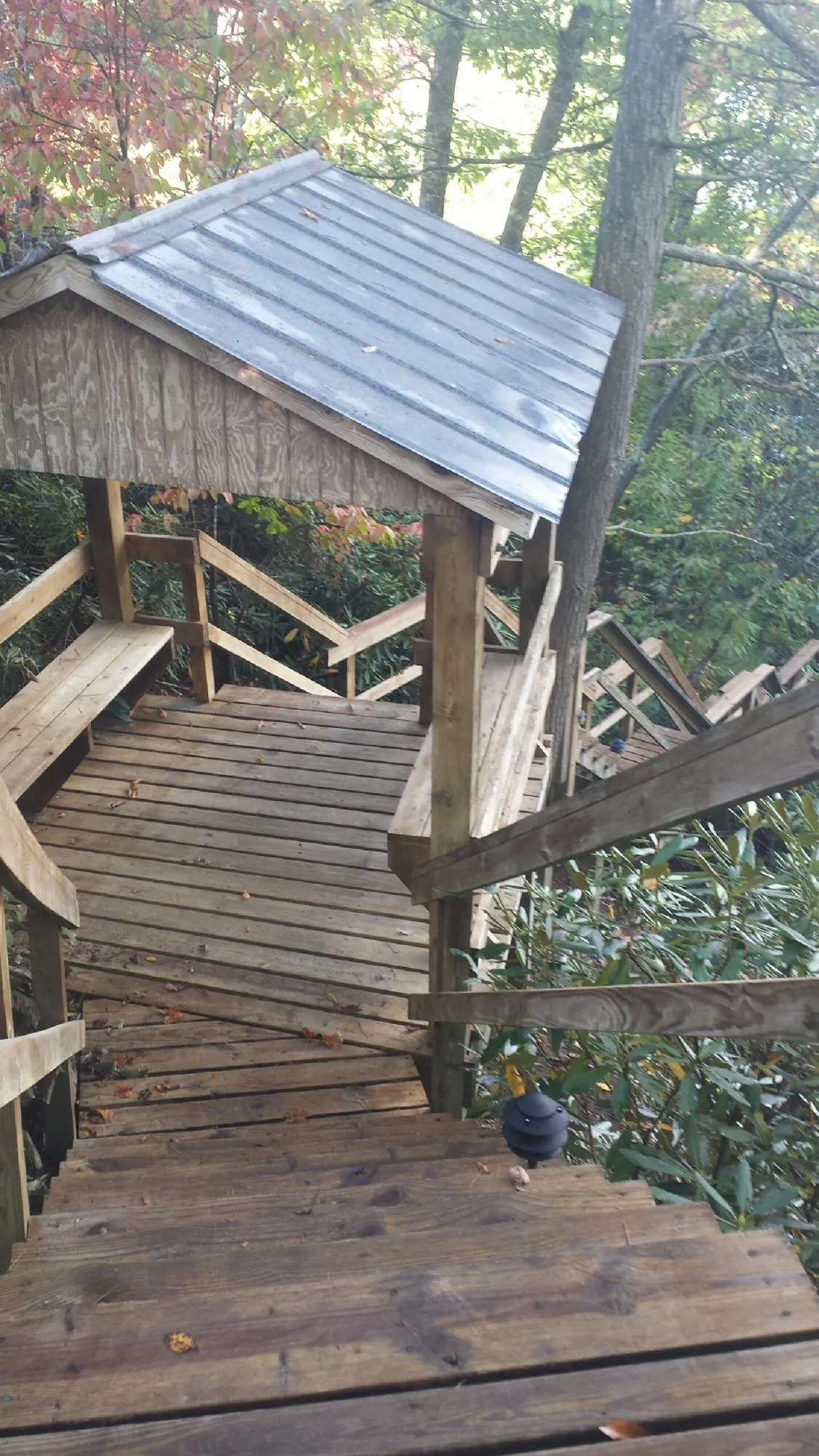 Metal roofed shelter over wooden steps on a wooded walkway — Skylight Repair & Installation work by our crew in Triadelphia