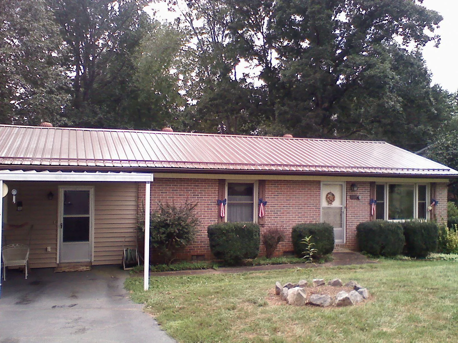 Bronze metal roof and carport on a brick ranch home — Roof Repair work by our crew in Triadelphia