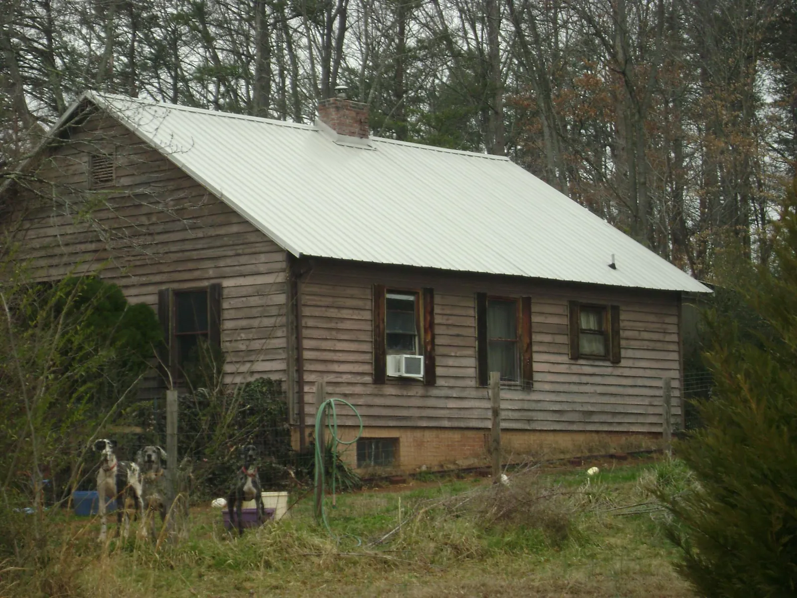 White metal roof on an old wood sided farmhouse, from a Metal Roof Installation job in Triadelphia